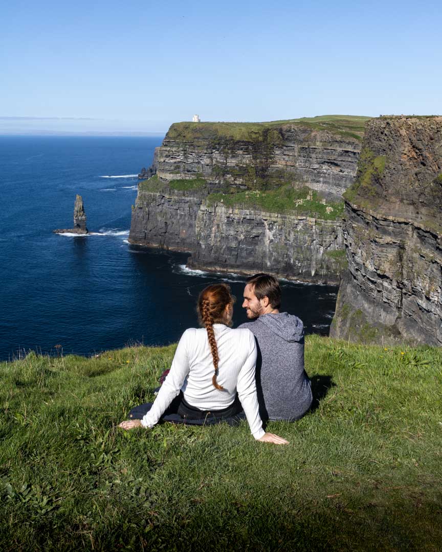 Couple sitting at a Cliffs of Moher viewpoint